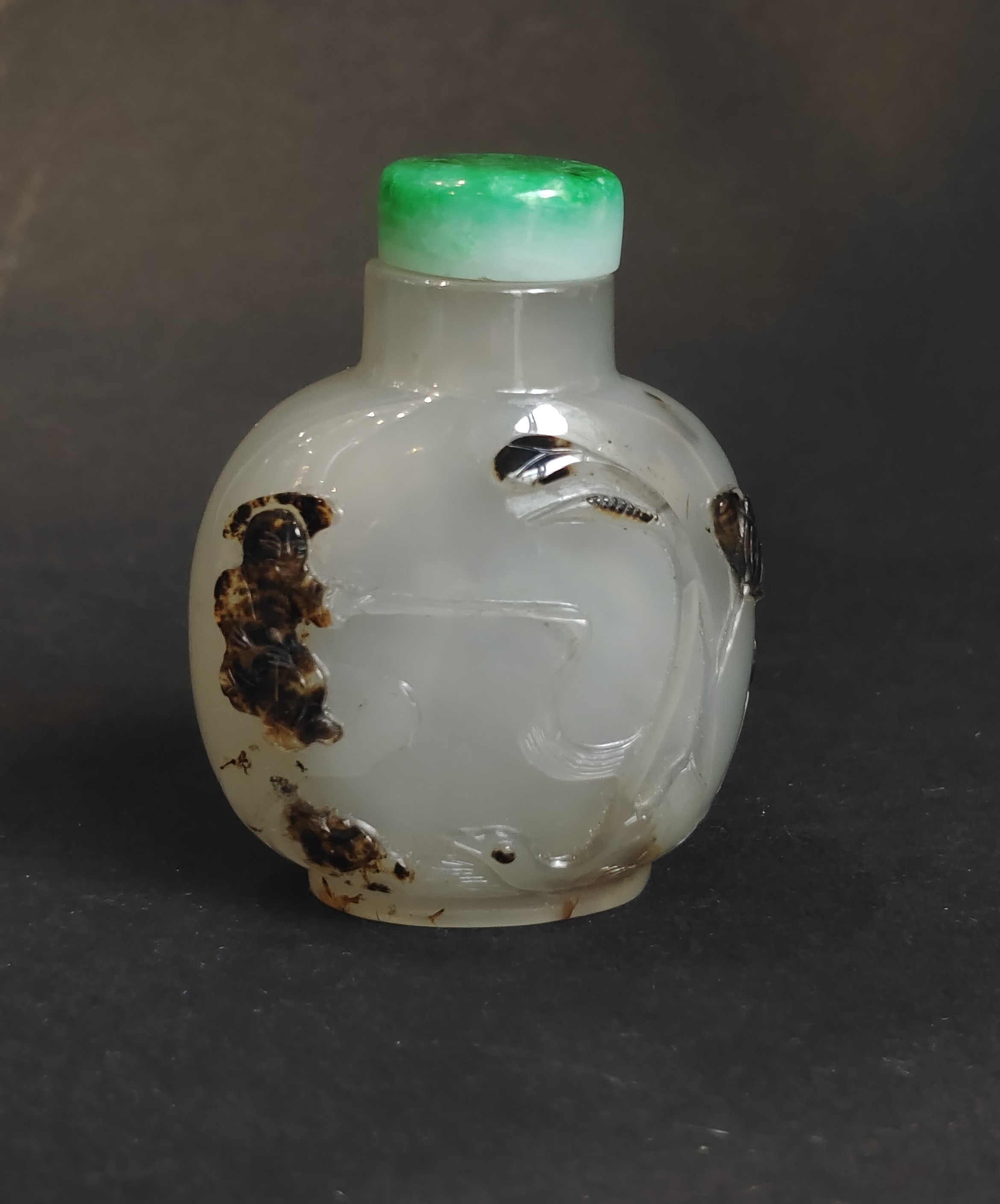 Very well hollowed agate snuff bottle carved in a brown vein from a fisherman at the edge of the water with duck and frog near lotus and millet - on the reverse Zhang Qian on a tree trunk forming a boat -
China official school 1750/1850